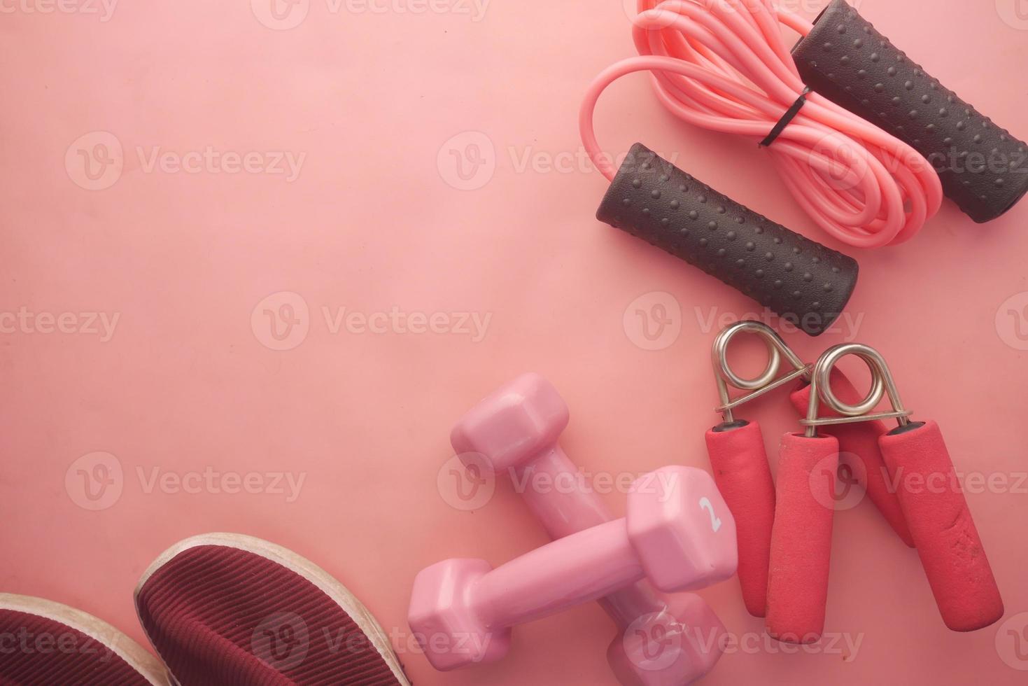 pink color dumbbell, exercise mat and water bottle on white