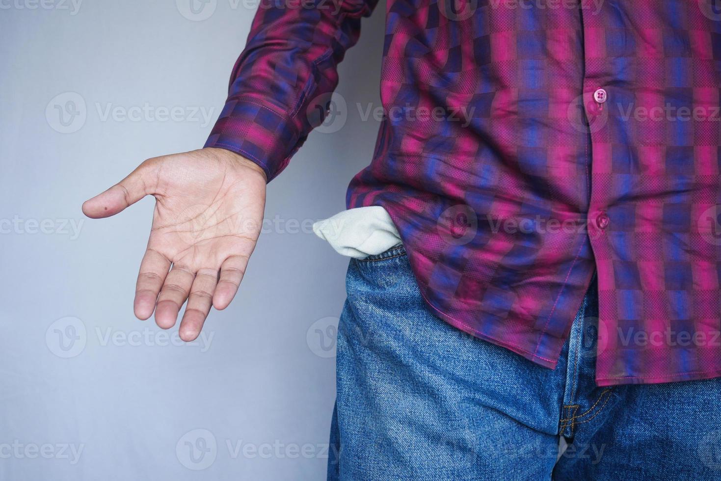 young man shows empty pant pocket with copy space photo