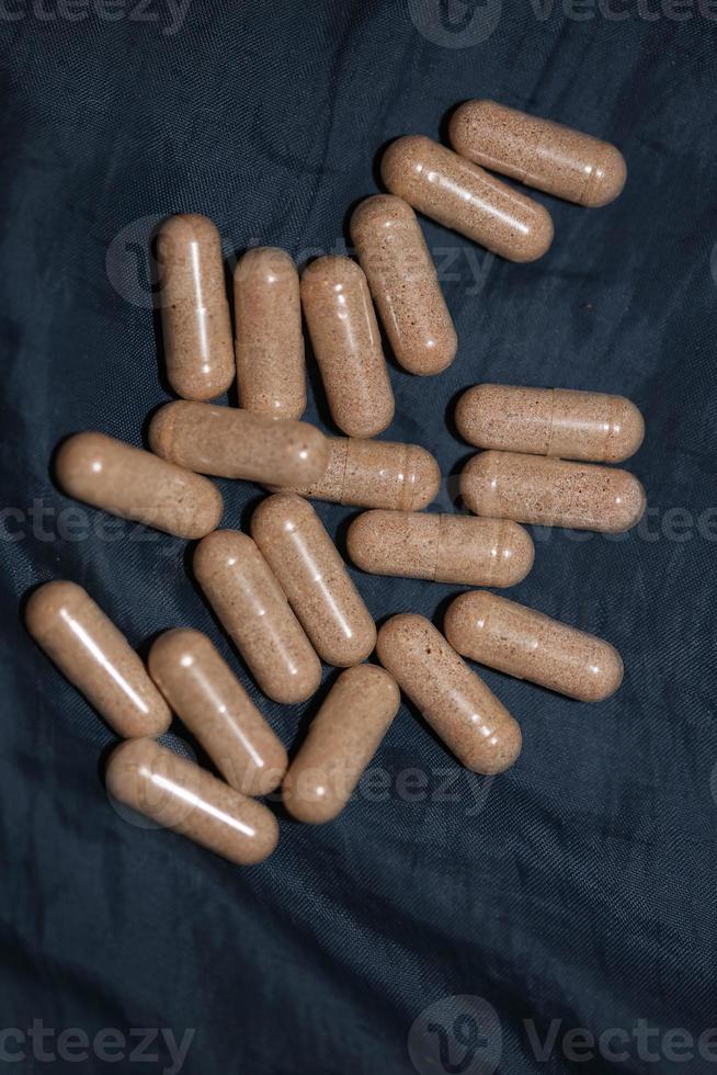 Transparent capsules filled with brown vitamins powder close up background high quality big size prints photo