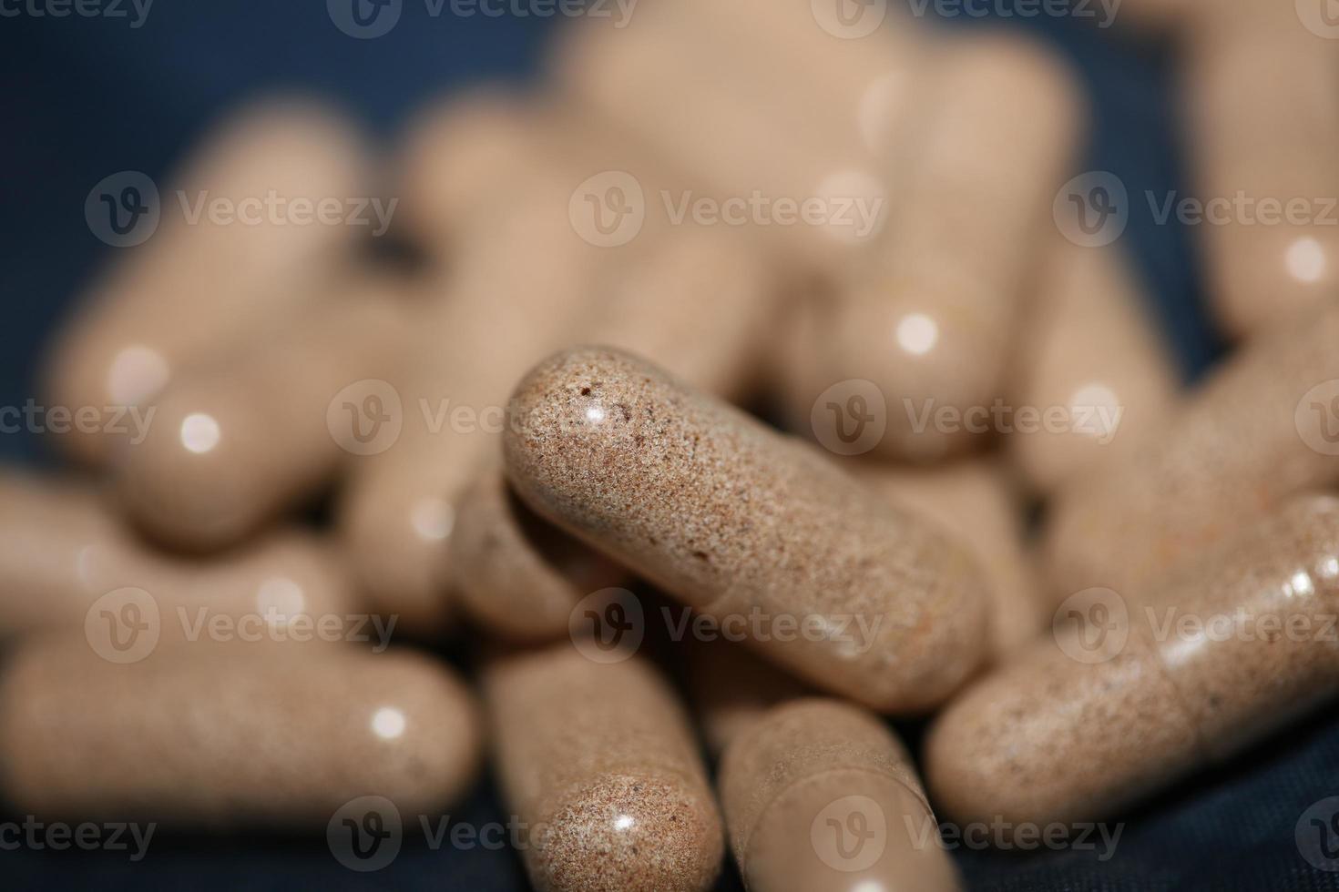 Transparent capsules filled with brown vitamins powder close up background high quality big size prints photo