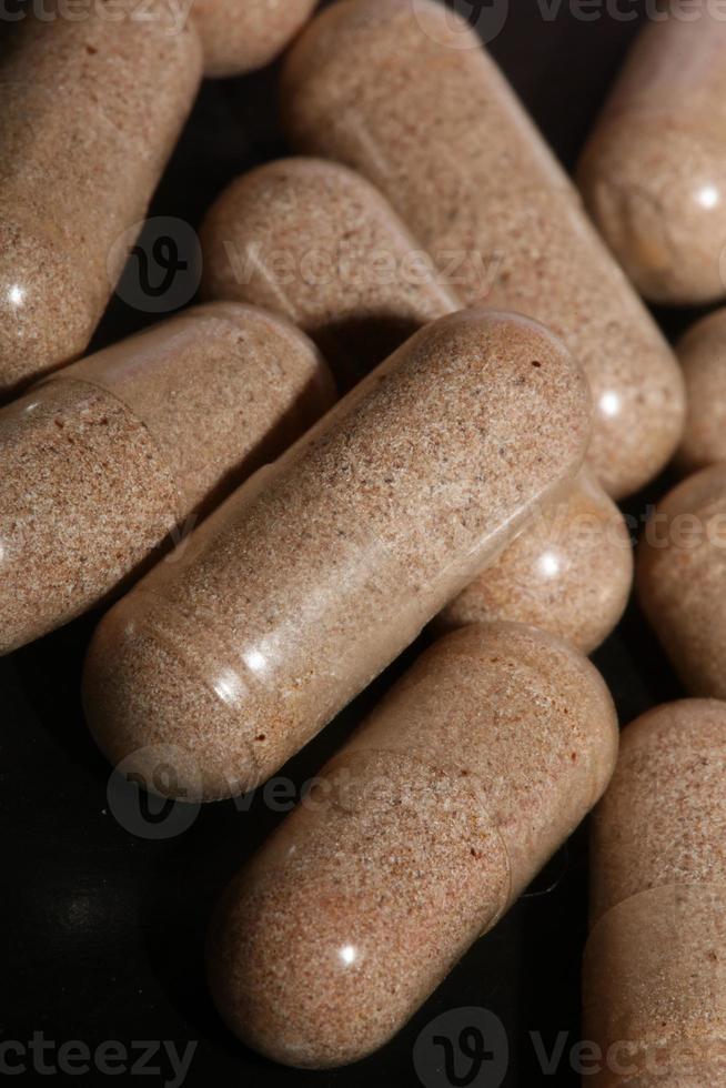 Transparent capsules filled with brown vitamins powder close up background high quality big size prints photo