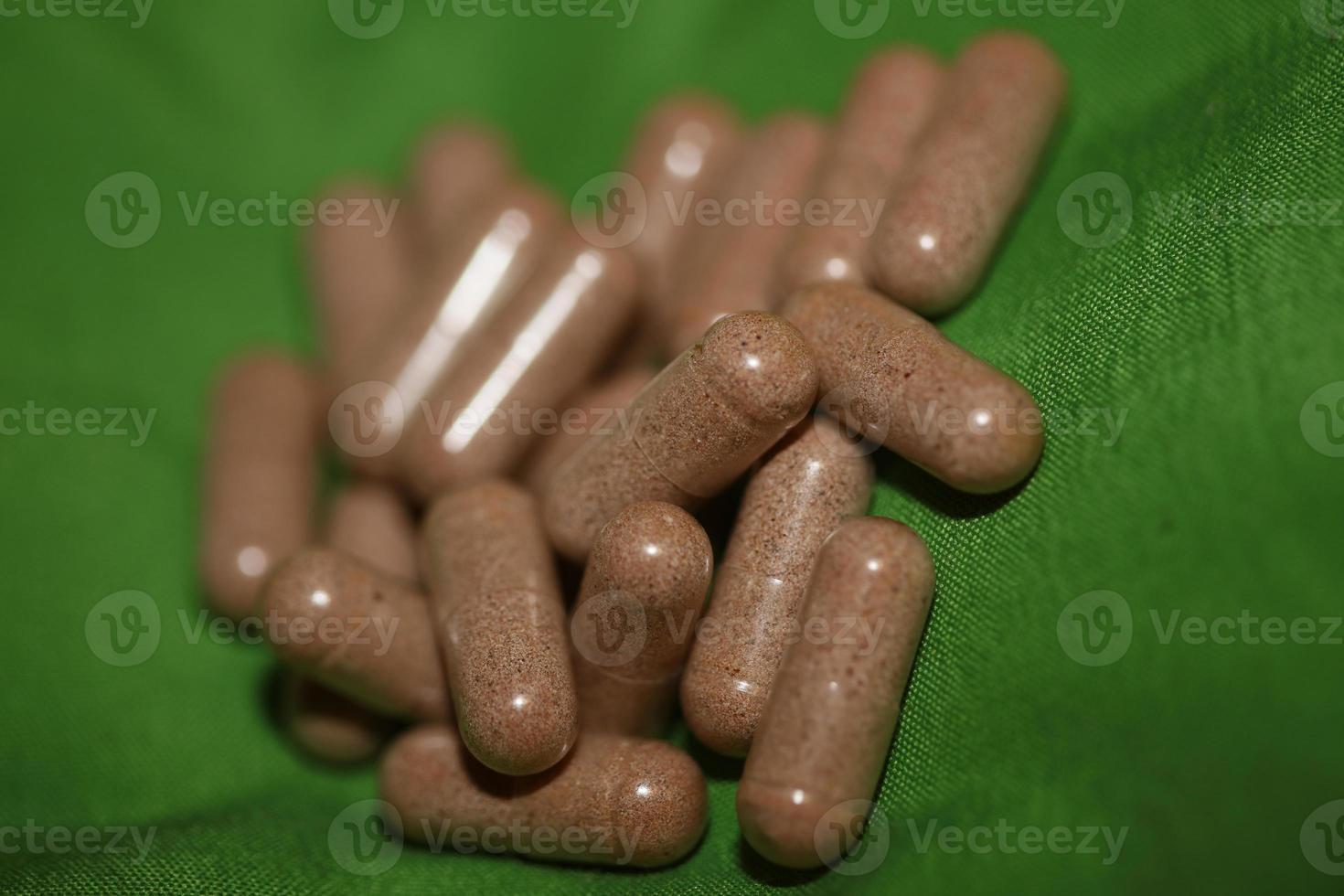 Transparent capsules filled with brown vitamins powder close up background high quality big size prints photo