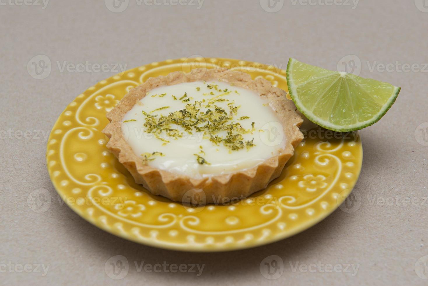 Vista lateral de la tarta de limón en un plato con rodajas de limón sobre la mesa. foto