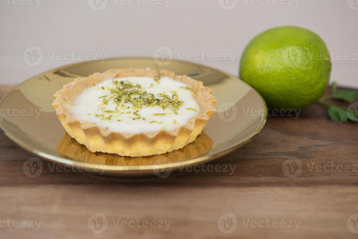 Vista lateral de la tarta de limón en un plato con rodajas de limón sobre la mesa. foto