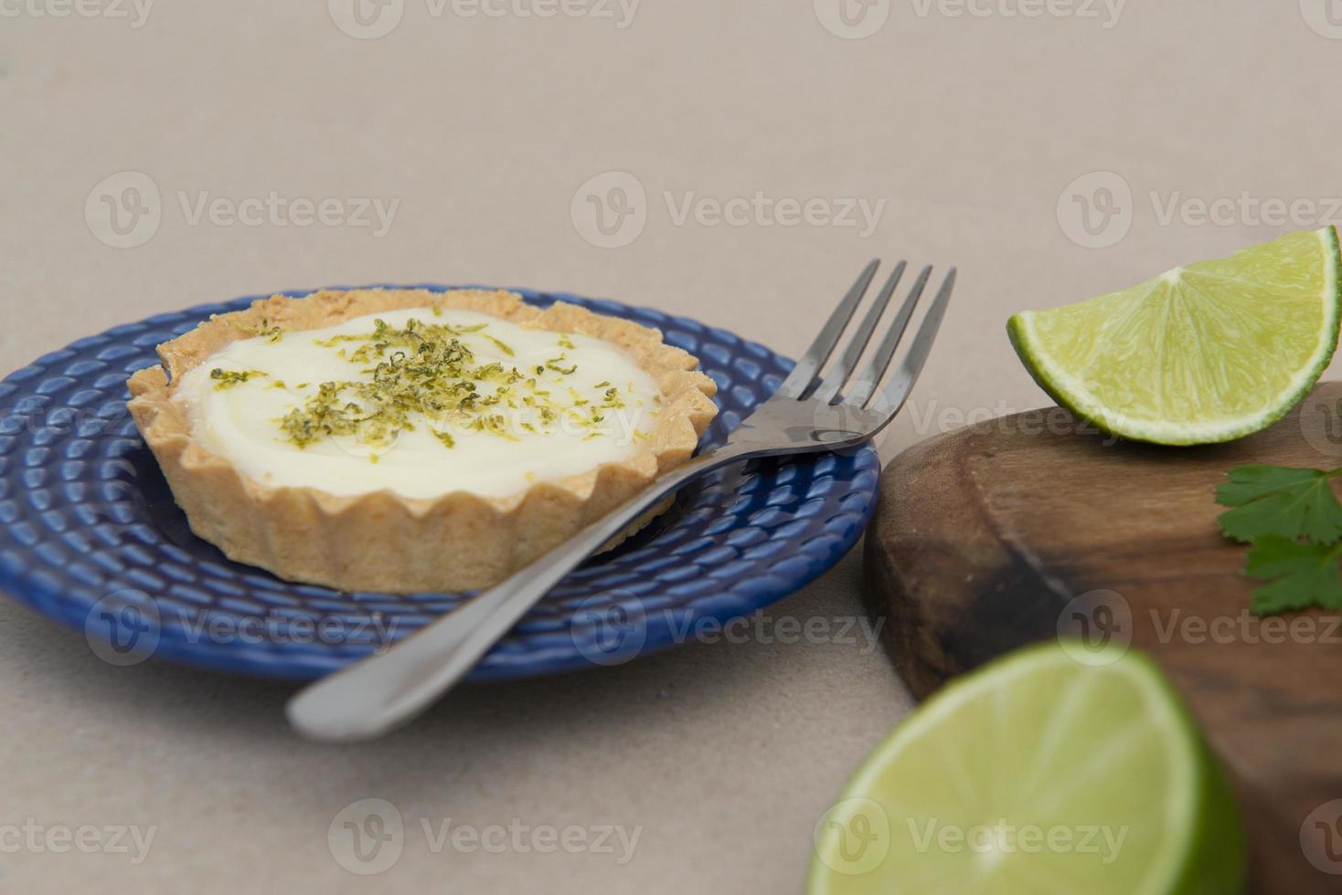 Vista lateral de la tarta de limón en un plato con rodajas de limón sobre la mesa. foto