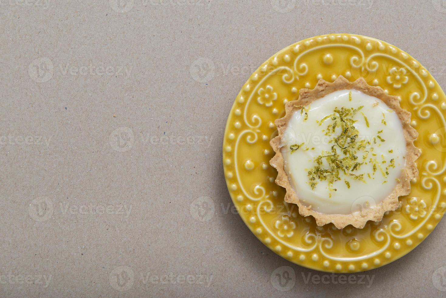 Vista superior de la tarta de limón en un hermoso plato vintage amarillo. foto