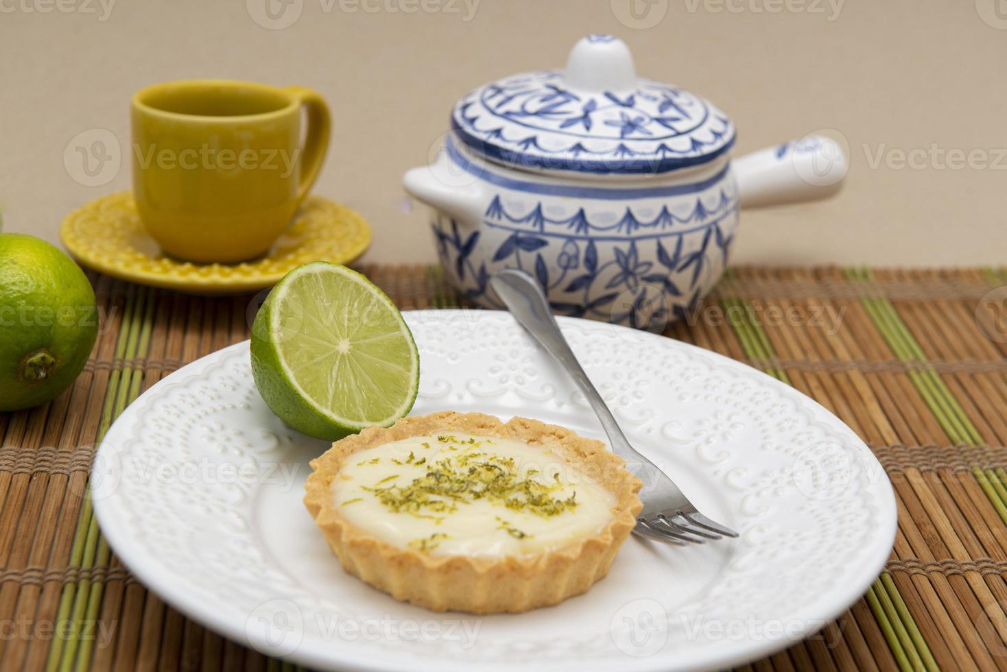 Vista lateral de la tarta de limón en un plato con rodajas de limón sobre la mesa. foto