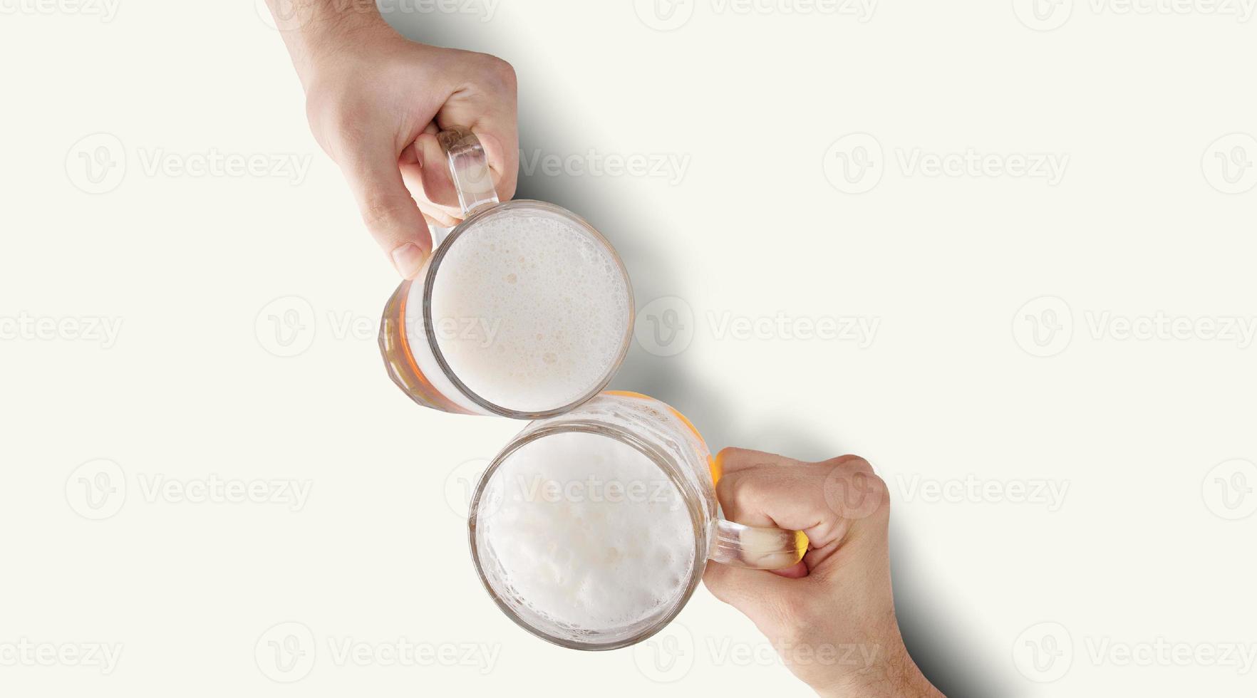 dos manos brindando refrescante cerveza fría. foto