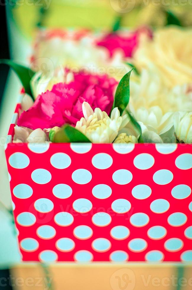 Beautiful bouquet of mixed flowers of chrysanthemums, cloves and roses in red box photo