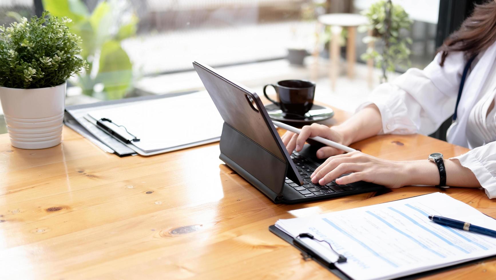 Close up Business woman using calculator and laptop for do math finance on wooden desk in office and business working background, tax, accounting, statistics and analytic research concept photo