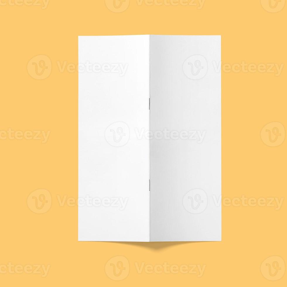 Top up view blank white brochure vertical upside down open isolated on bright brown background. photo