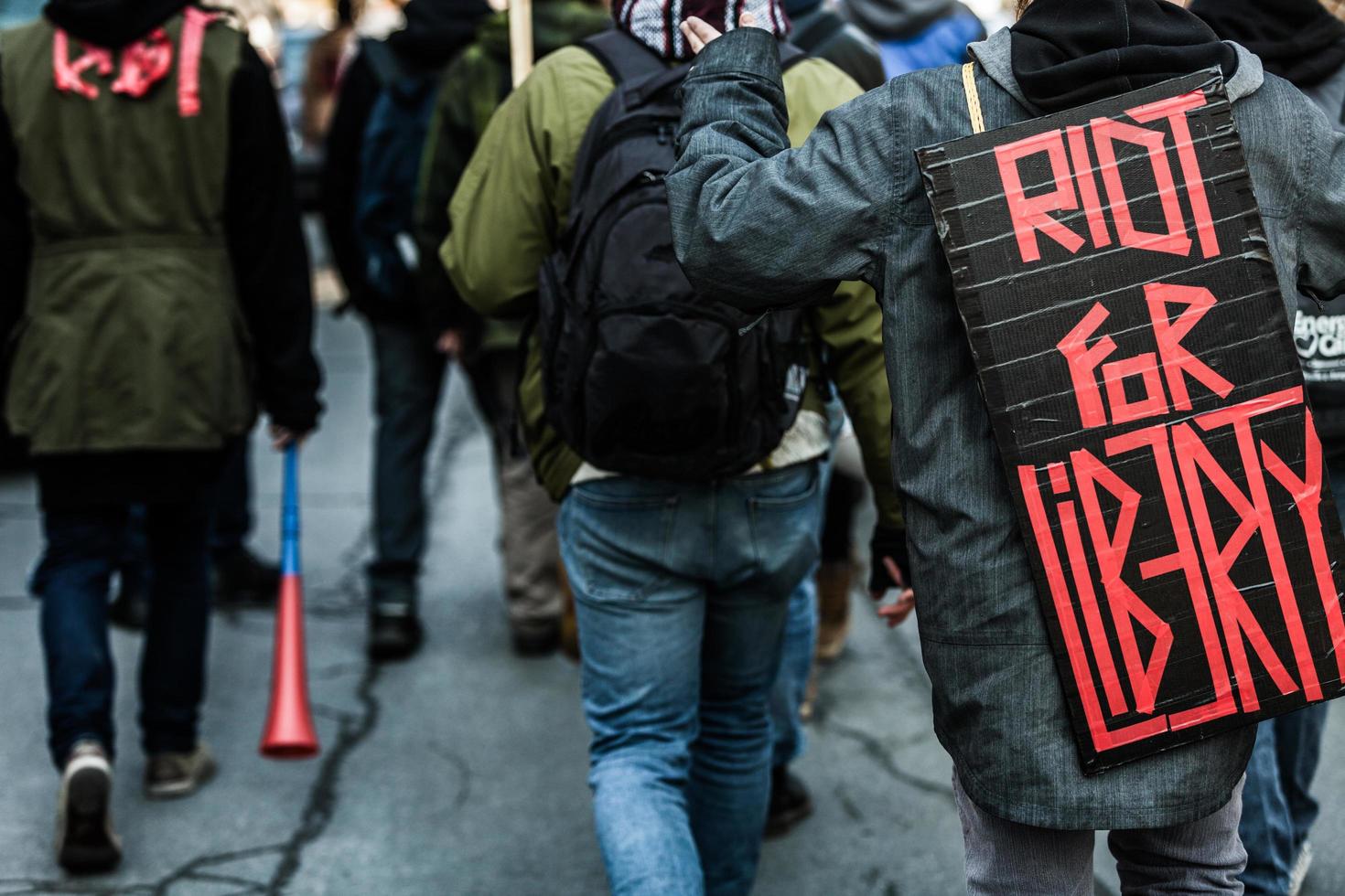 Montreal, Canadá, 02 de abril de 2015 - Primer plano de la parte de atrás de un manifestante con un cartel que decía disturbios por la libertad foto