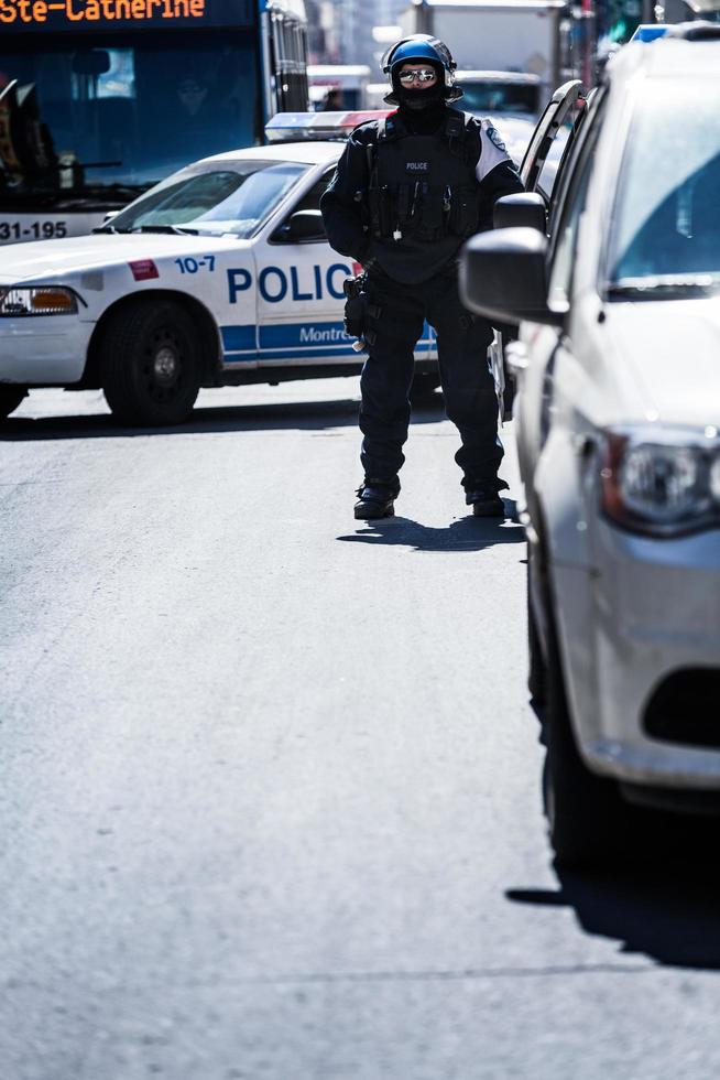 Montreal, Canadá, 02 de abril de 2015 - la policía sola mirando a los manifestantes en la calle Ste-Catherine foto