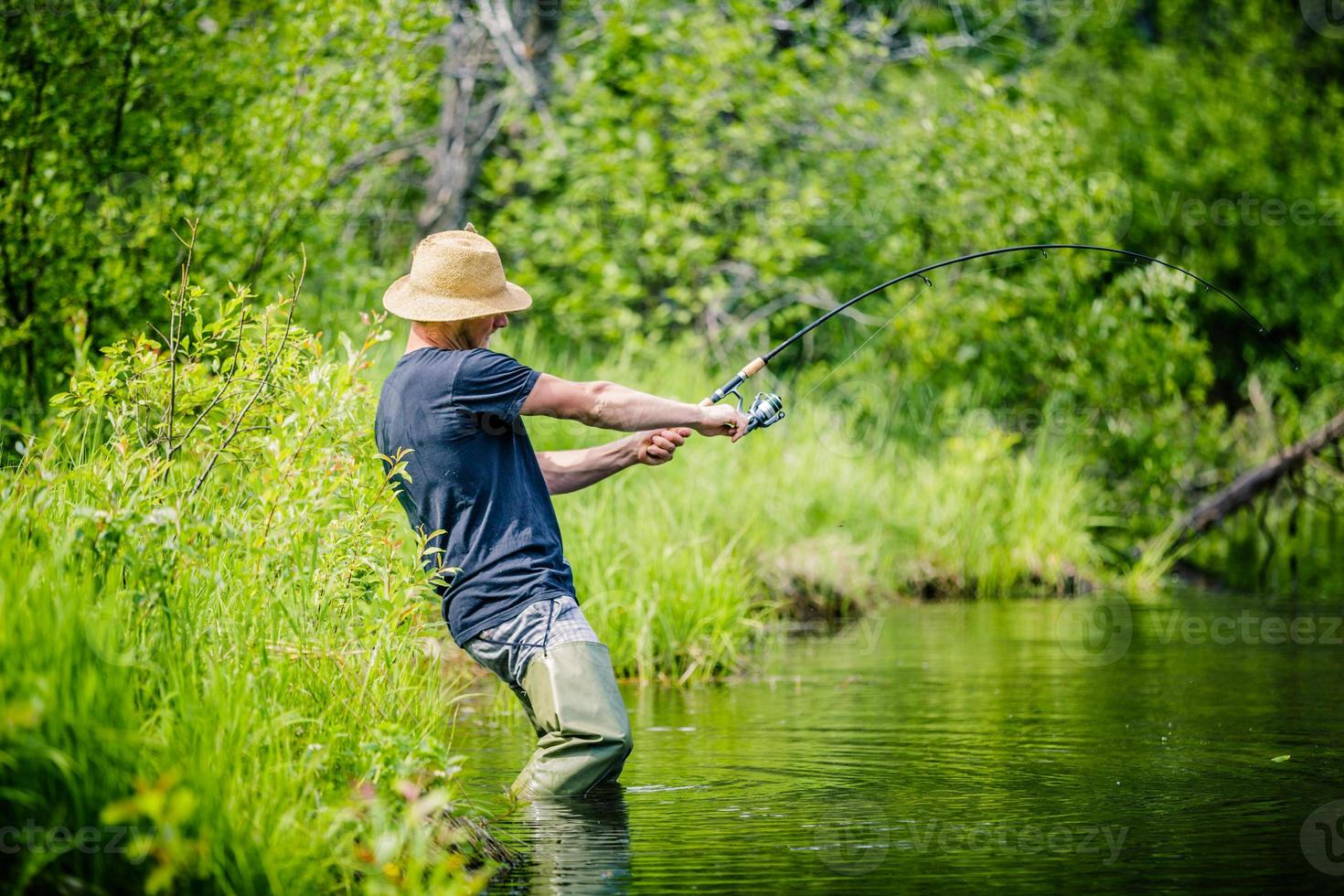 Young Fisherman Catching a big Fish photo