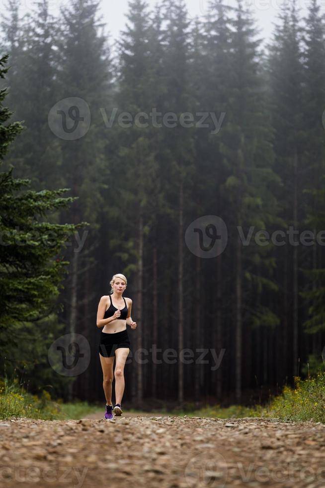 Jogger Training in Forest early in the Morning. photo