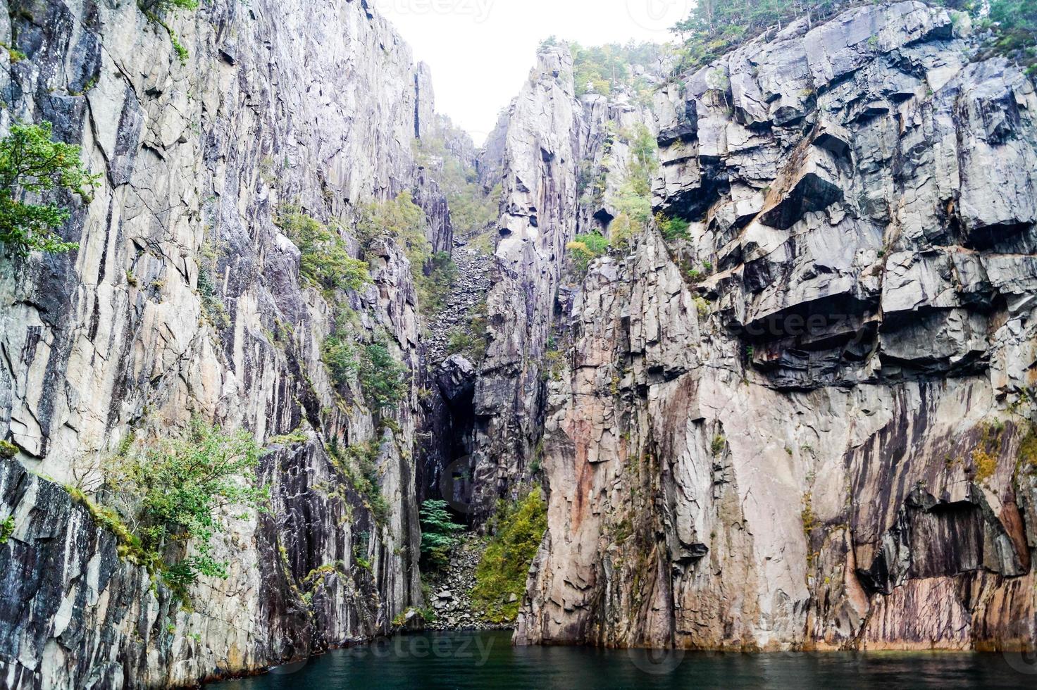 Formación rocosa en el lysefjord con la famosa cascada hengjanefossen foto