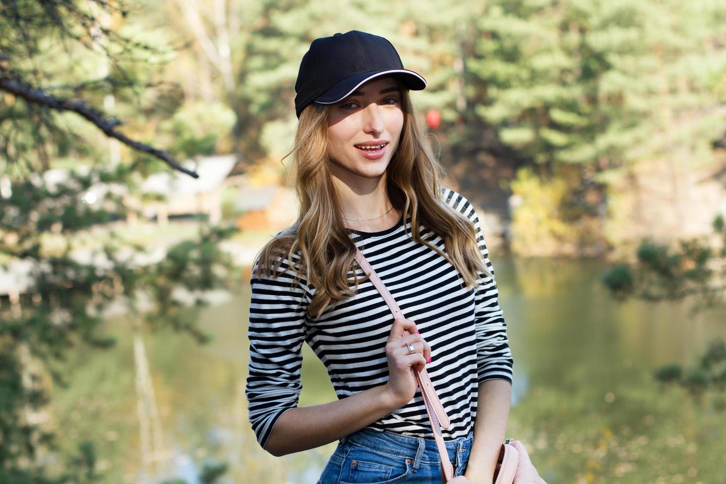 Enjoying the nature. Young woman in black blazer enjoying the fresh air in green forest. Portrait Of A Caucasian Woman Smiling photo