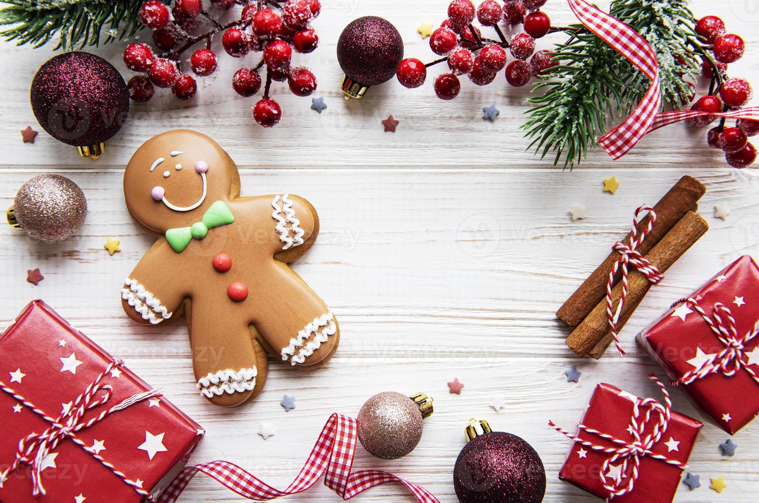 Pan de jengibre navideño con adornos navideños en la mesa de madera blanca foto