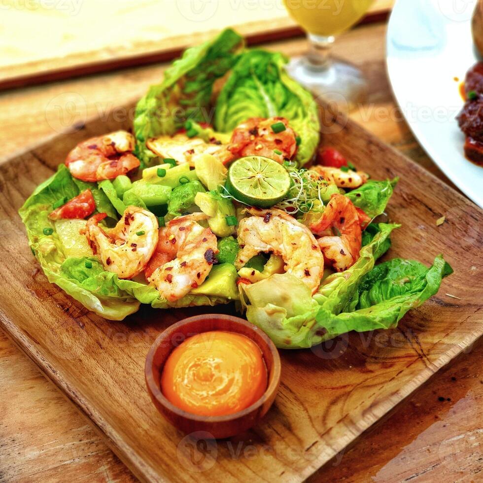 salad with shrimp and dressing on a plate photo