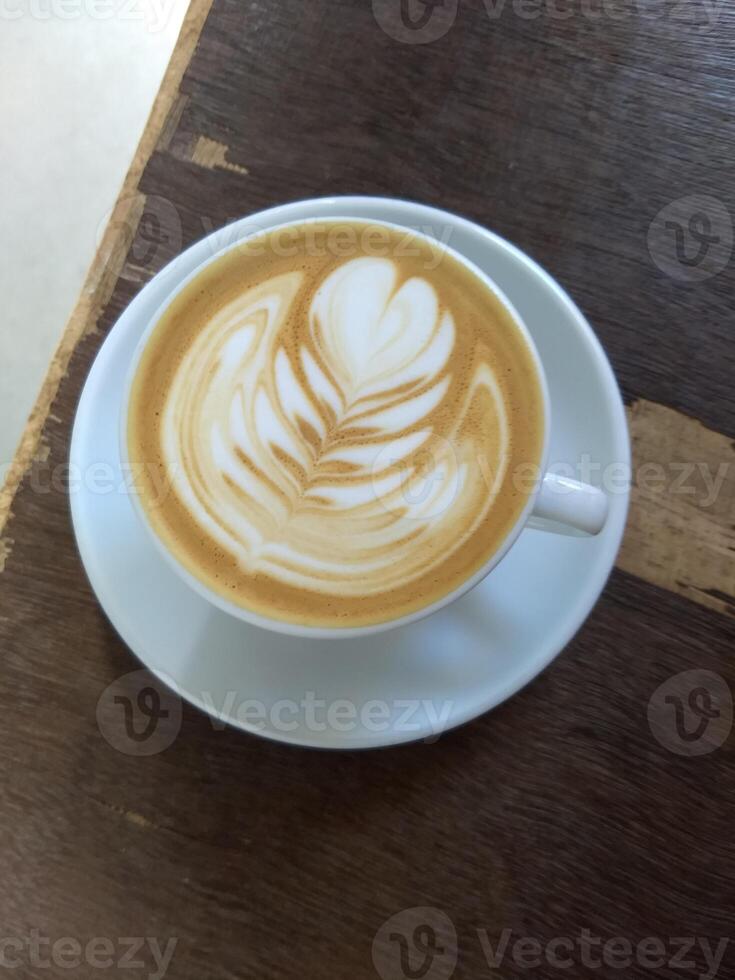 cappuccino in a white cup on a wooden table photo