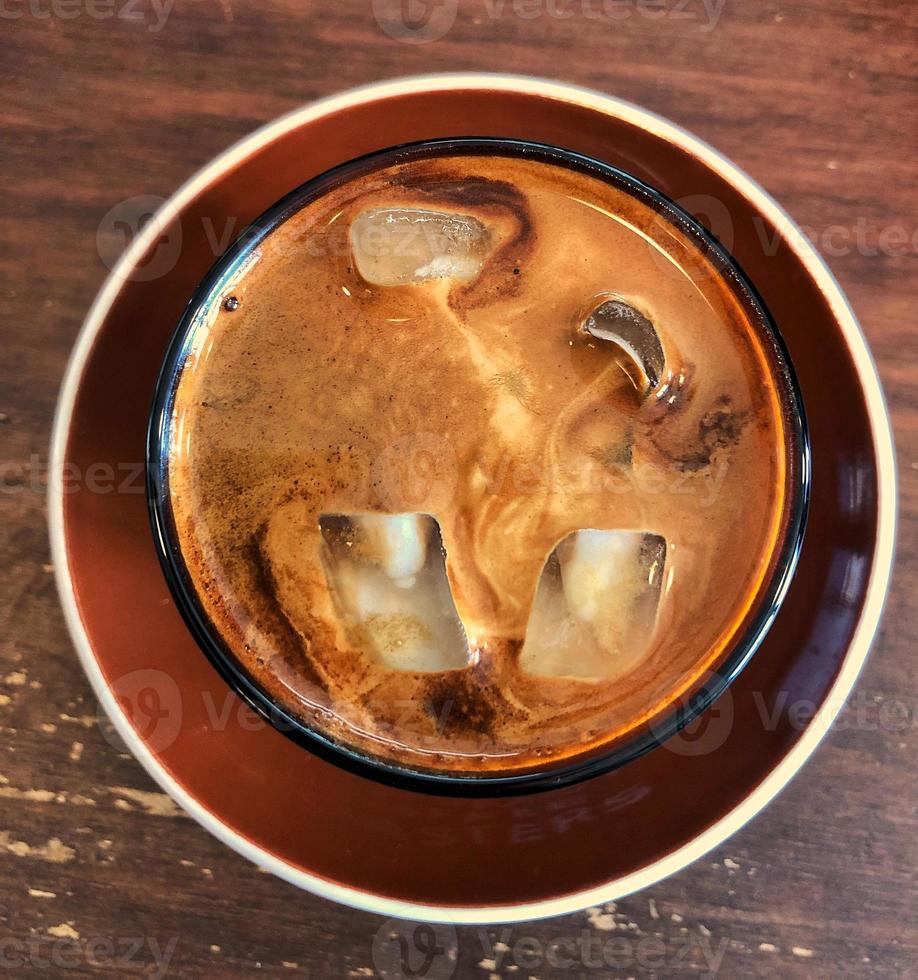 café con leche con cubitos de hielo en un vaso sobre la mesa foto