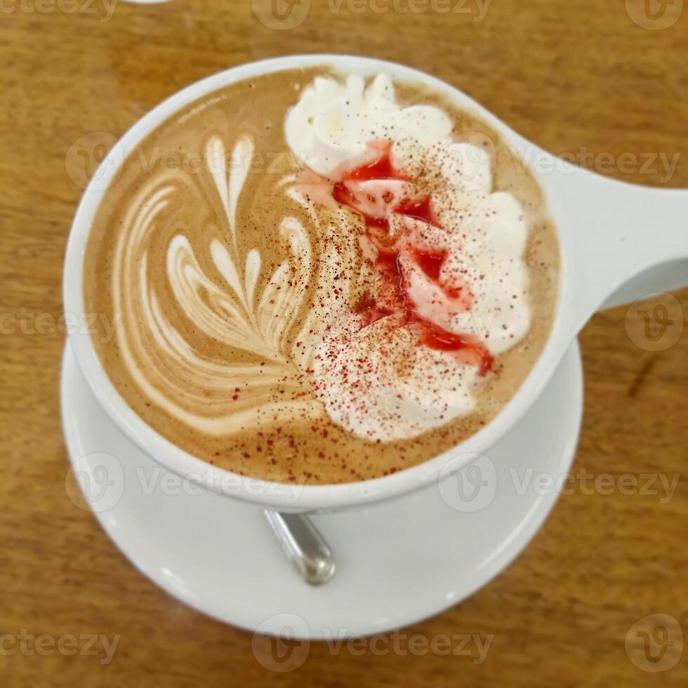 coffee milk with a hint of red and heart-shaped in a white cup photo