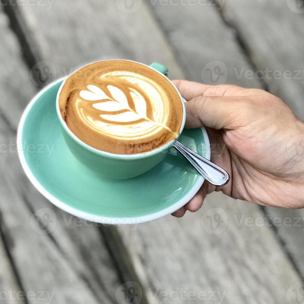 café con leche de forma única dentro de una taza verde foto