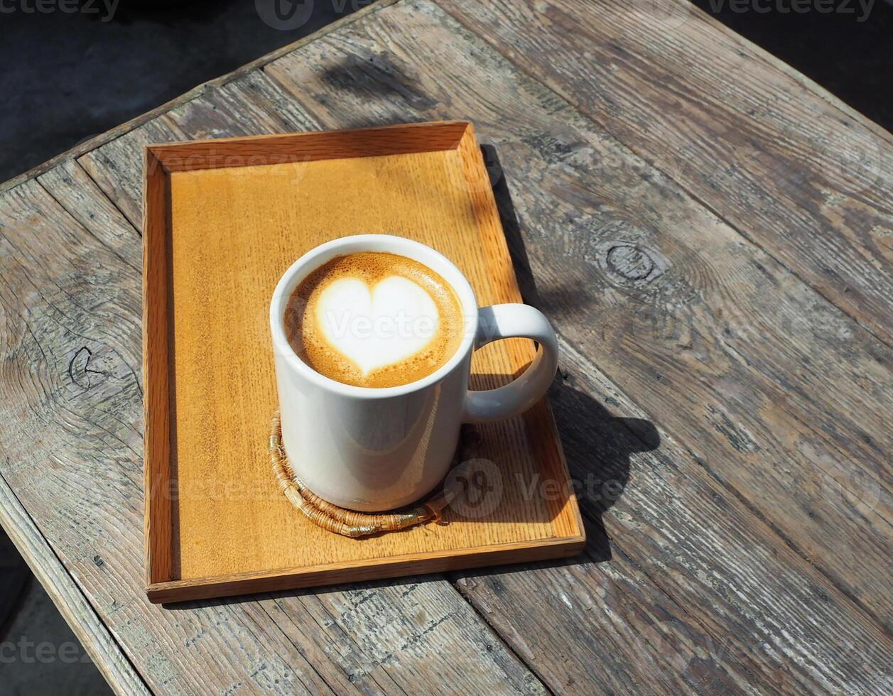 Beautiful heart-shaped milk coffee in clear white glass photo