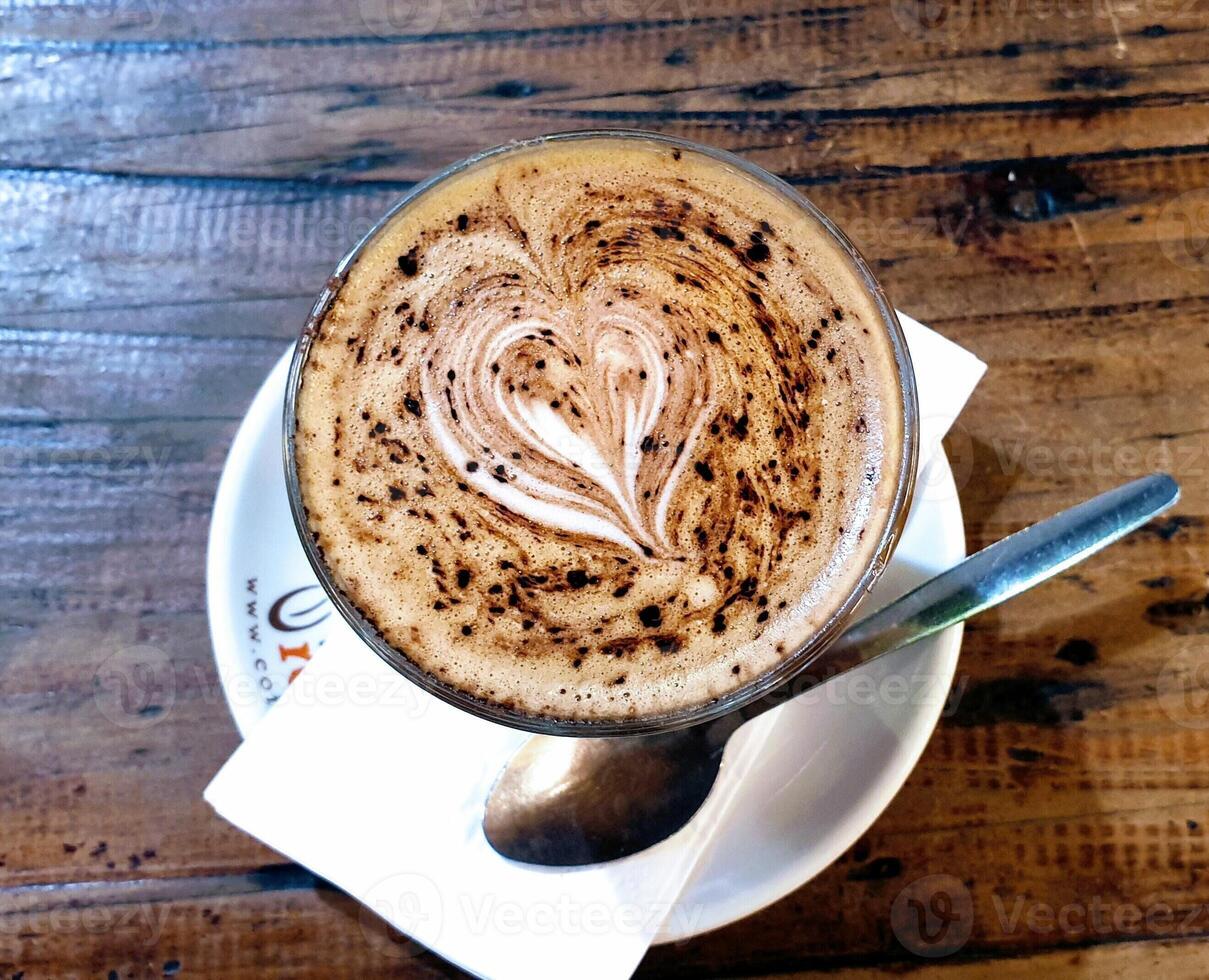 Milk coffee with a heart shape that dots chocolate in a white cup photo