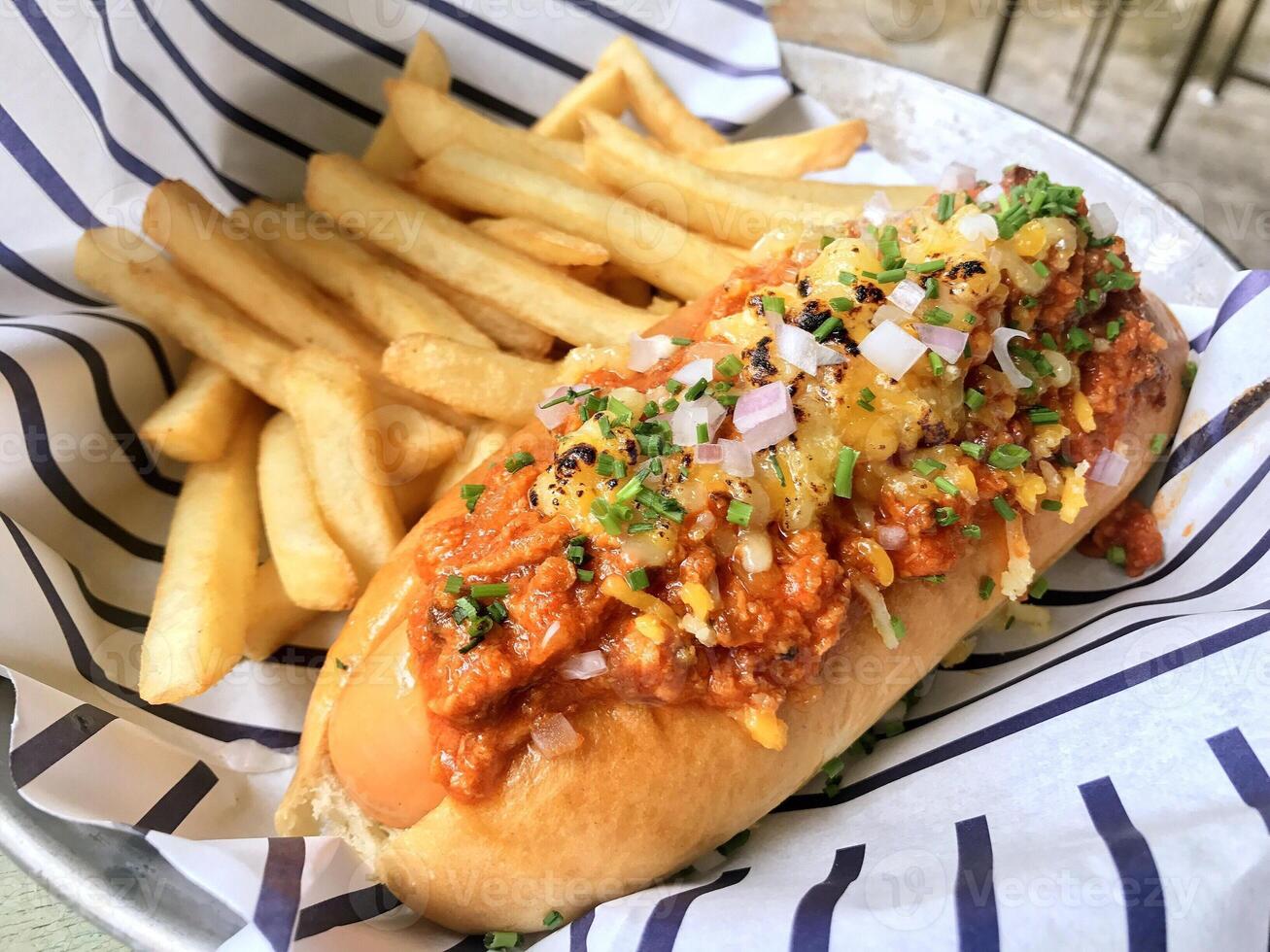 hotdog with sausage and french fries and sauce on a plate photo