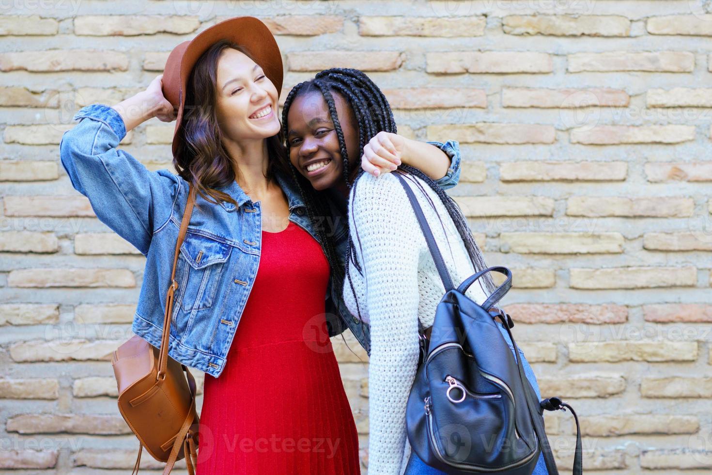 dos amigos abrazándose en el fondo urbano. . amigos multiétnicos. foto