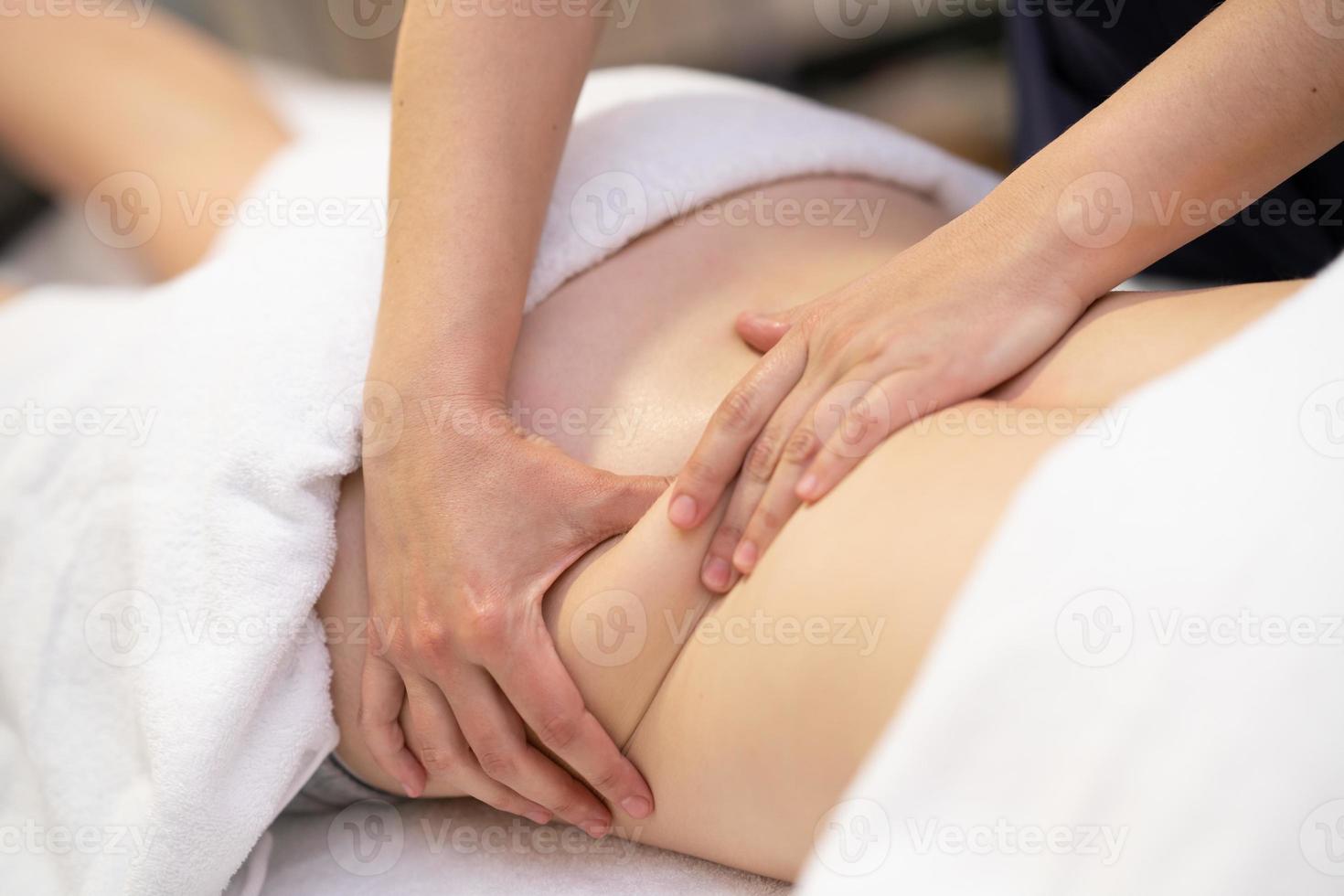 Young woman receiving a back massage in a physiotherapy center photo