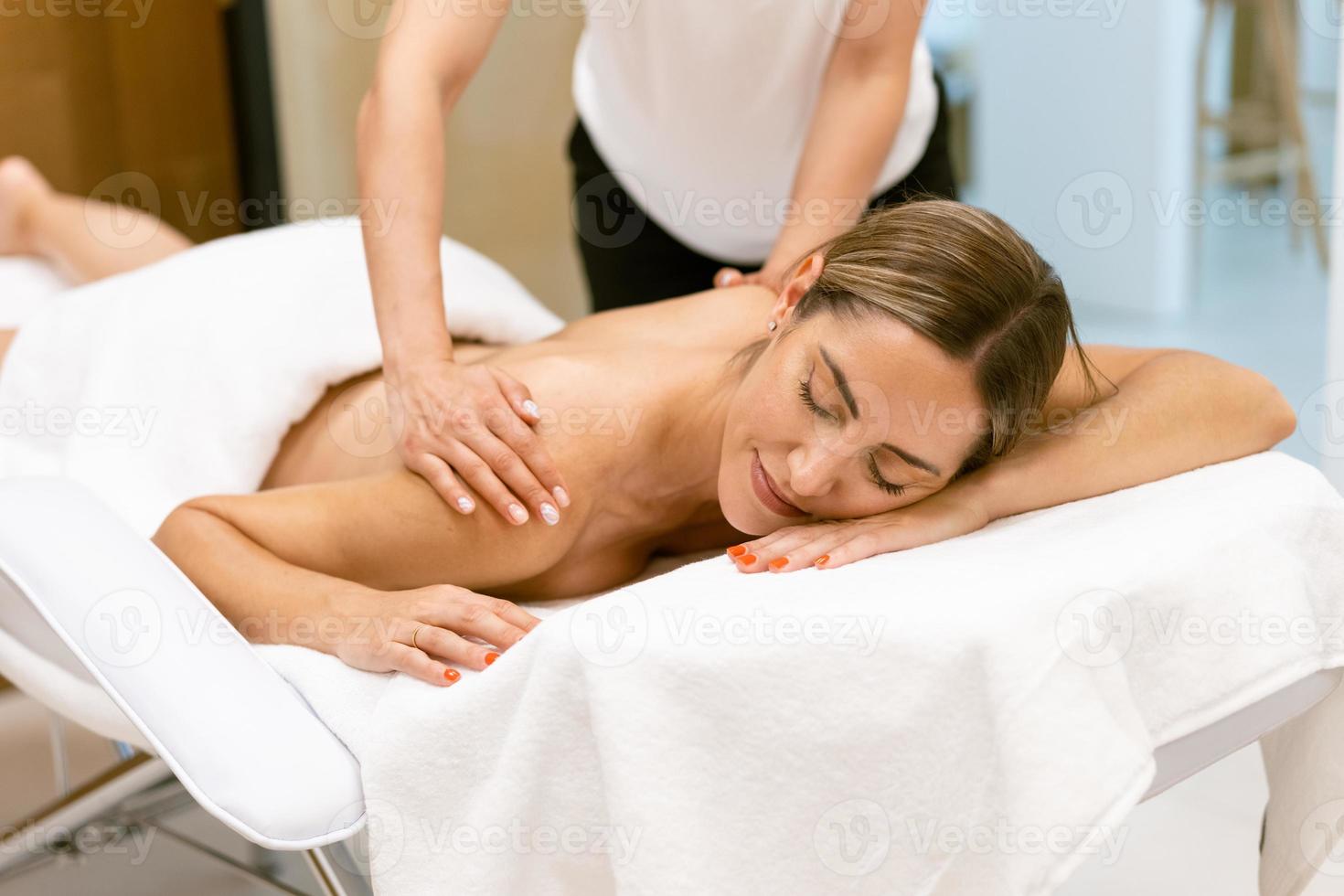 Middle-aged woman having a back massage in a beauty salon. photo