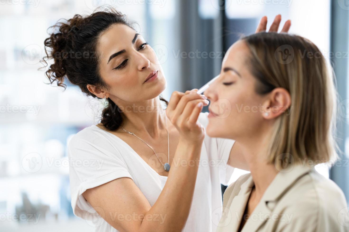 maquilladora árabe que compone a una mujer en un centro de belleza. foto