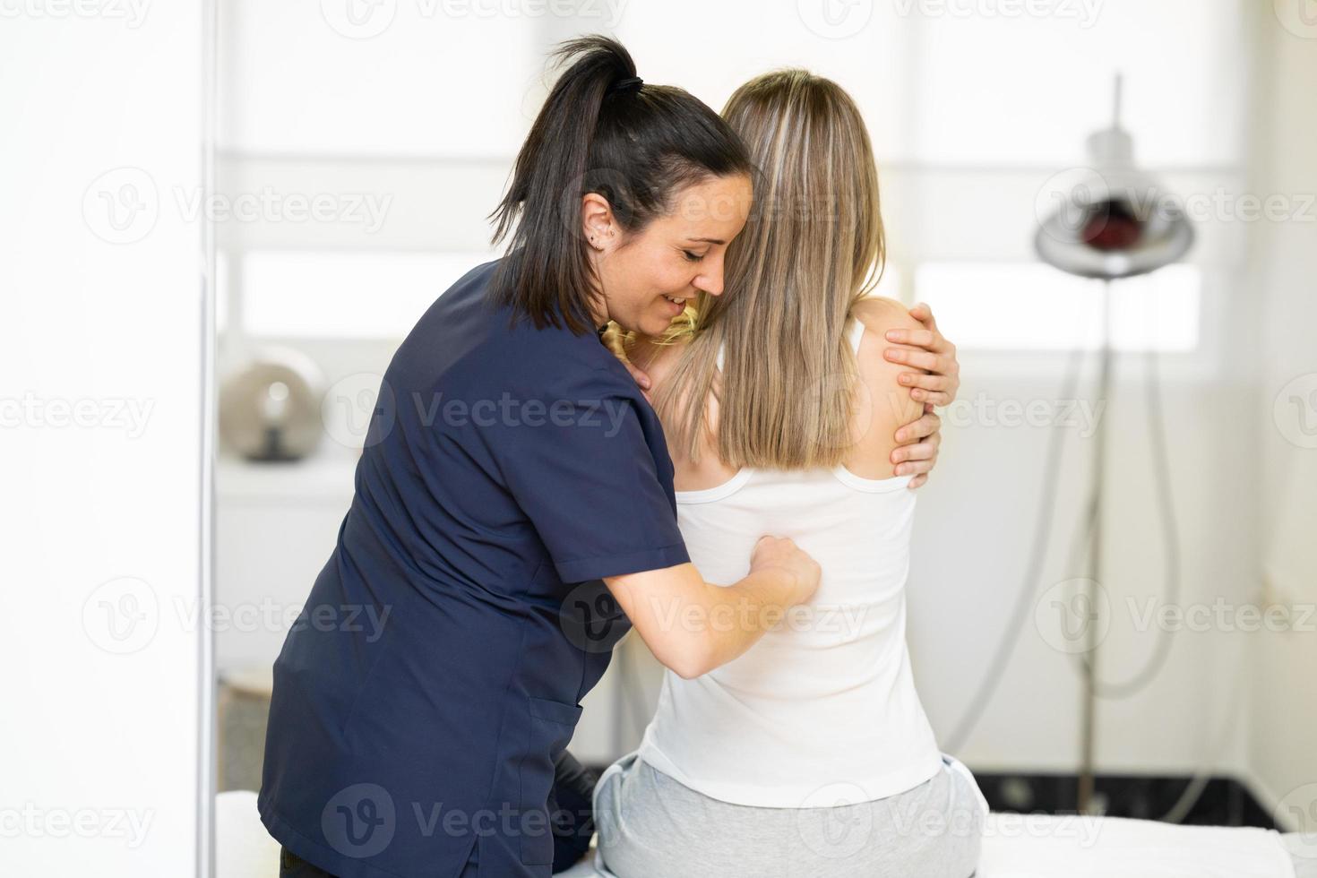 fisioterapeuta inspeccionando a su paciente en un centro de fisioterapia. foto