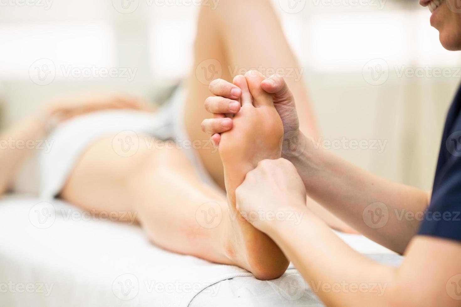 Medical massage at the foot in a physiotherapy center photo