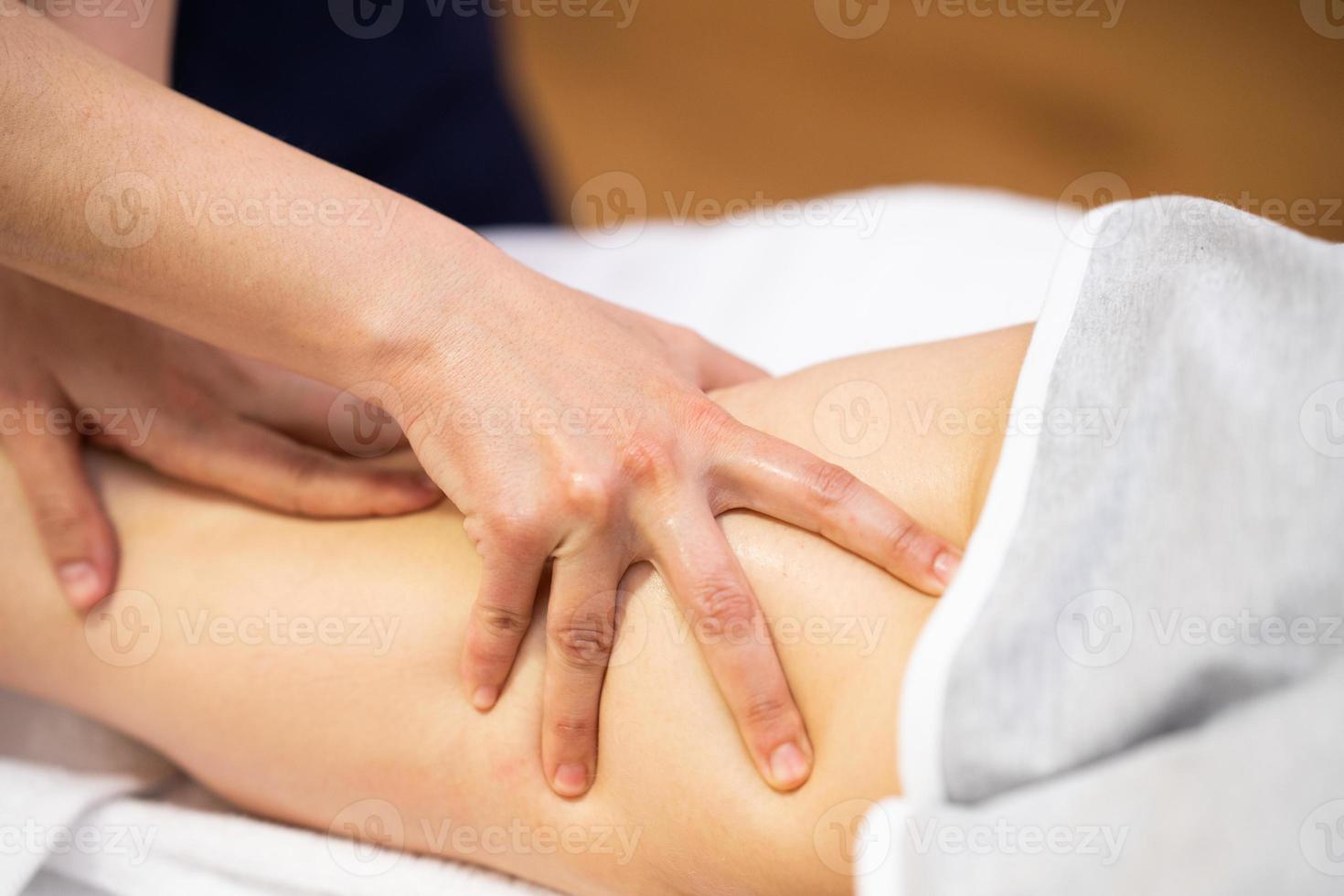 Medical massage at the leg in a physiotherapy center. photo