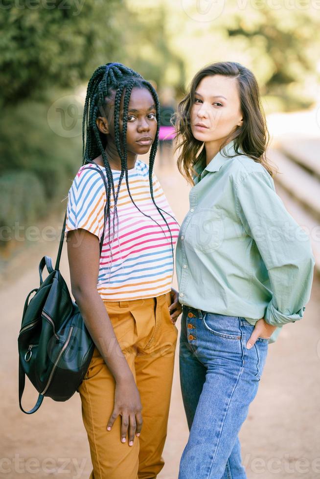 Two Multiethnic women looking at camera together on the street. photo