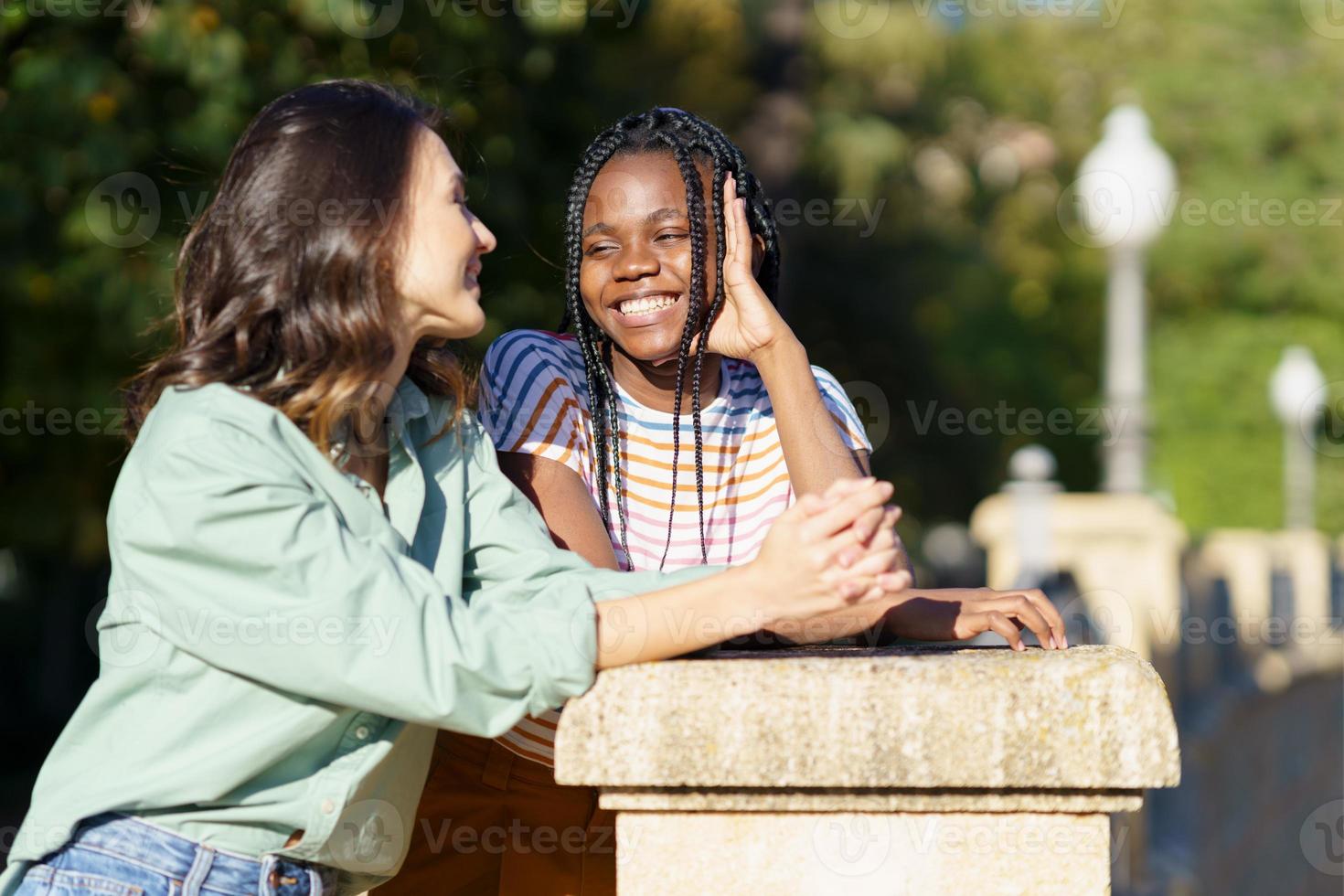 Two Multiethnic women talking together on the street. photo