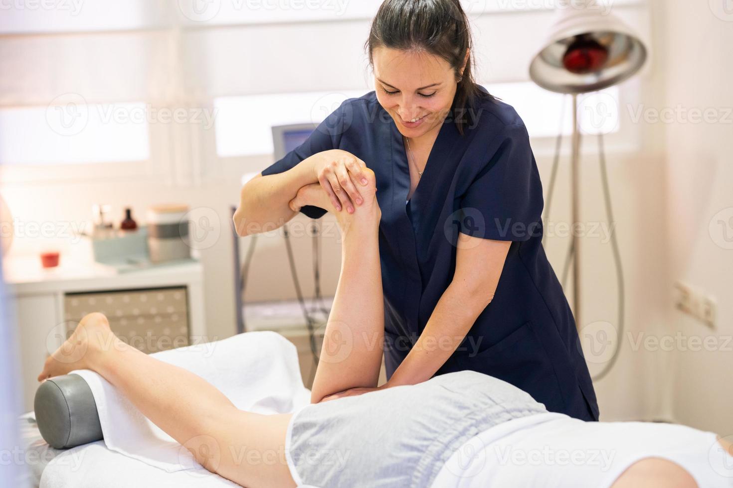 Medical massage at the leg in a physiotherapy center. photo