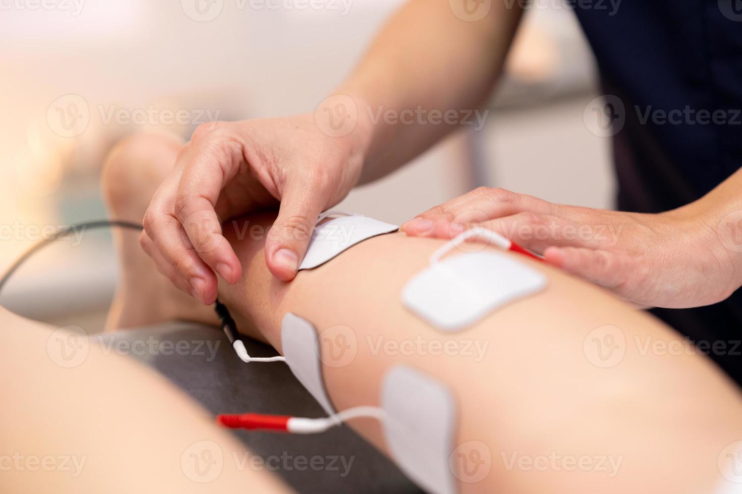 Electro stimulation in physical therapy to a young woman photo