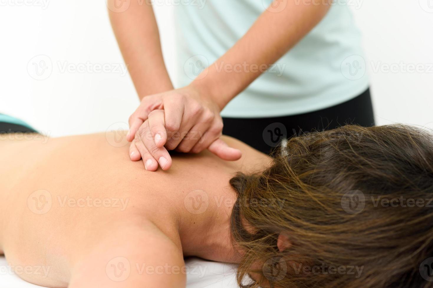 Young woman receiving a back massage in a spa center. photo