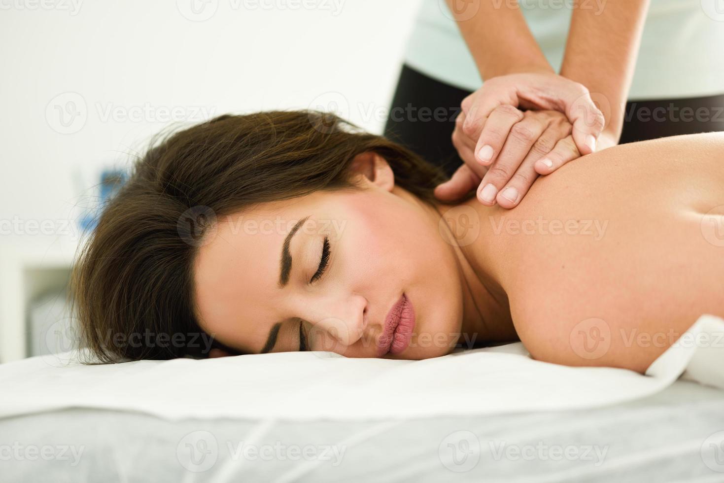Young woman receiving a back massage in a spa center. photo