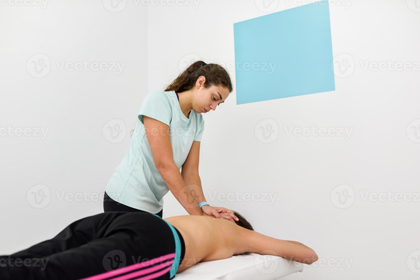 Young woman receiving a back massage in a spa center. photo