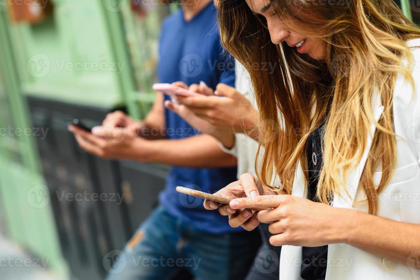 Group of people looking down at smart phone photo