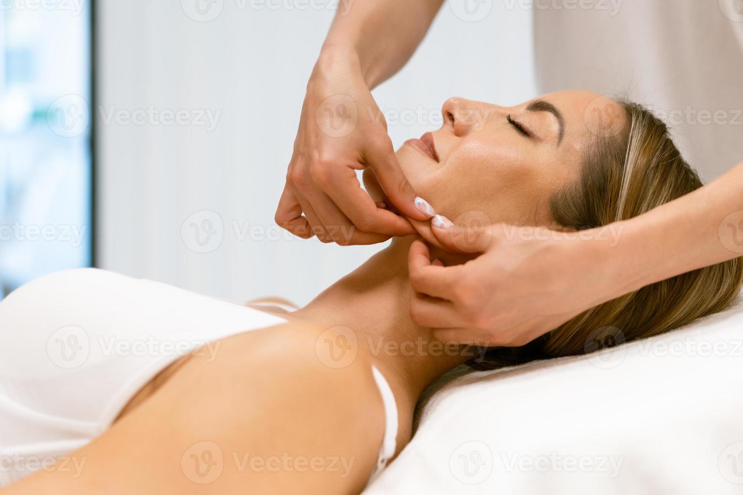 Middle-aged woman having a head massage in a beauty salon. photo