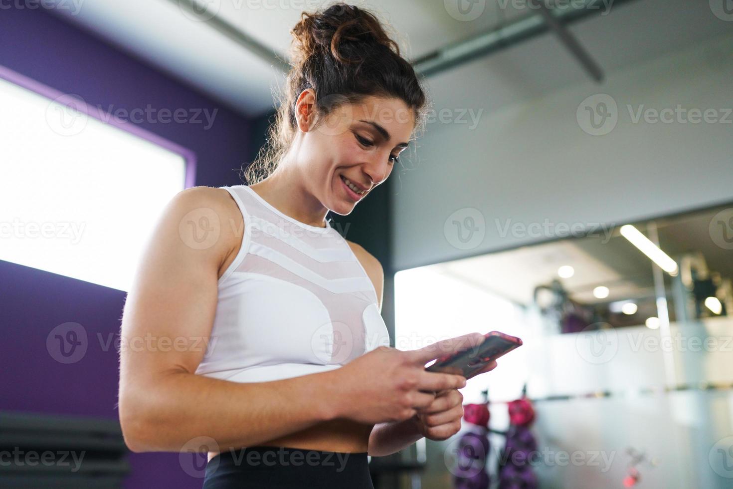 Woman consulting her training on her smartphone photo