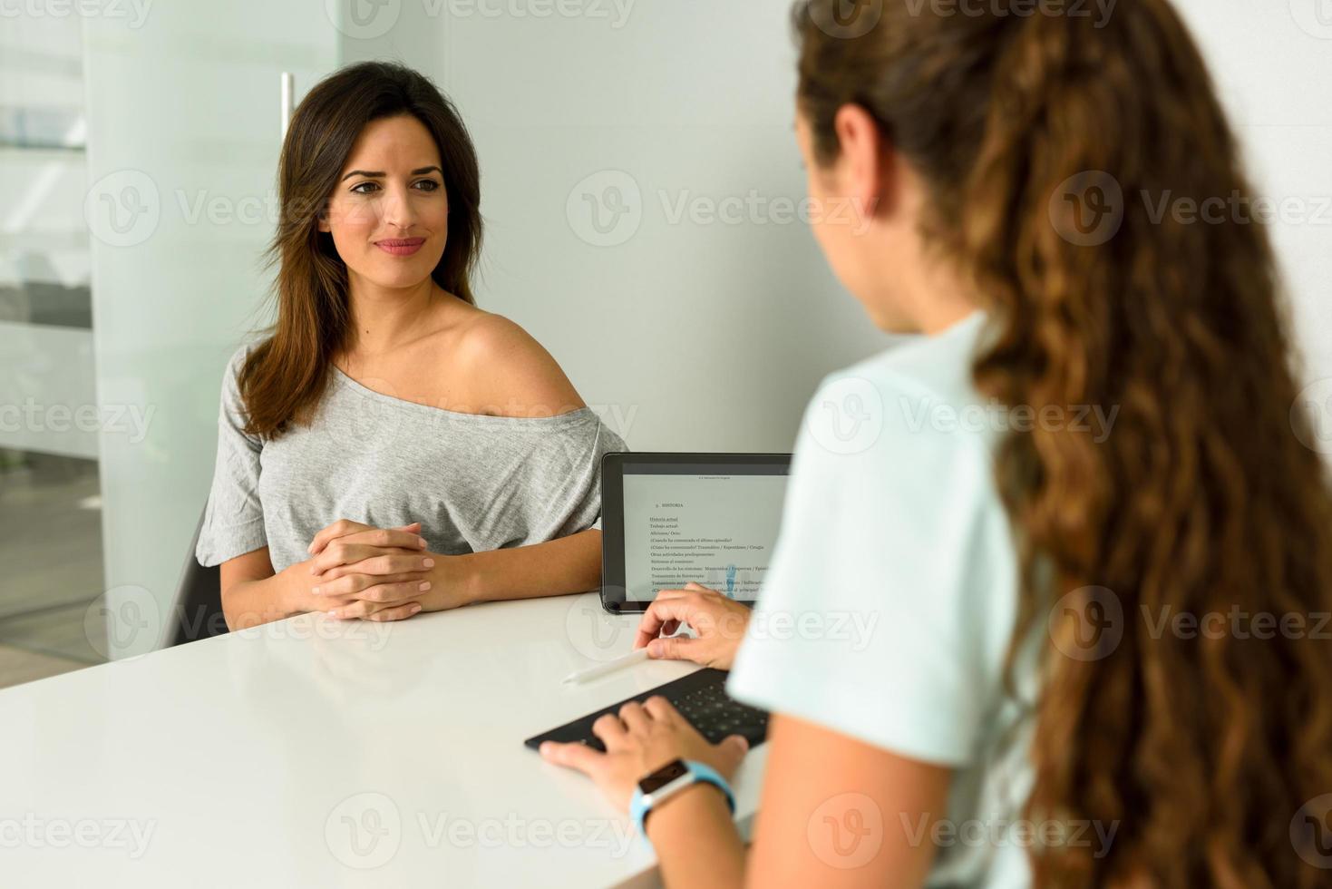 fisioterapeuta explicando el diagnóstico a su paciente. foto