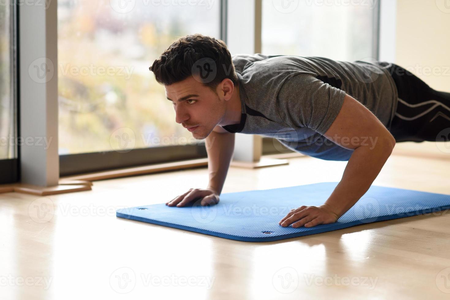 Attractive man doin pushups in the gym photo