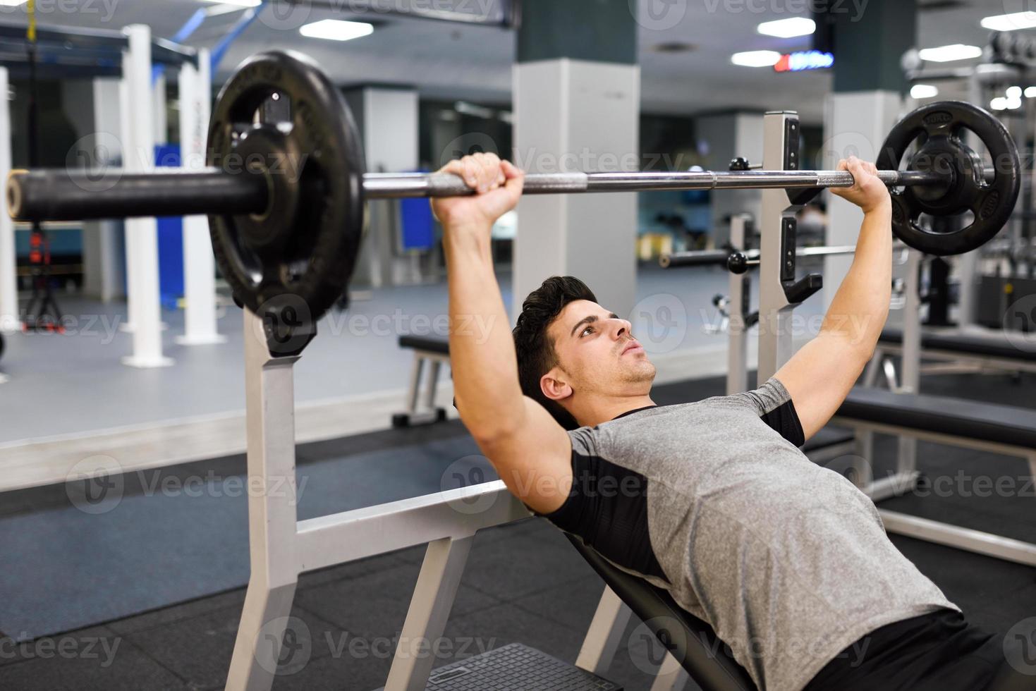 culturista joven haciendo levantamiento de pesas en el gimnasio. foto